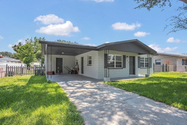 view of front of house with an attached carport, concrete driveway, fence, and a front lawn