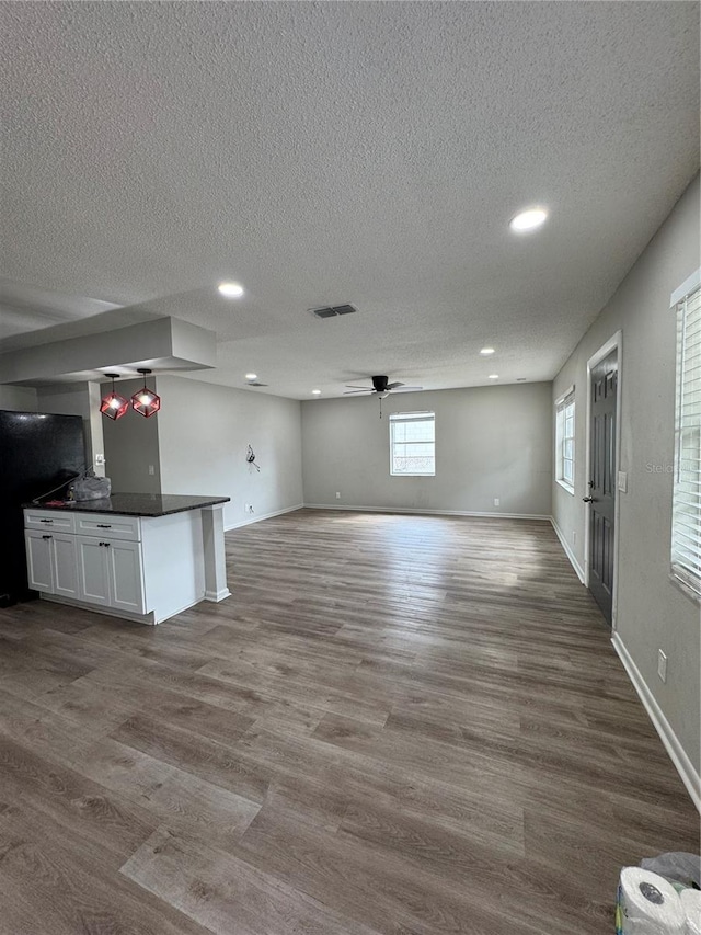 602 Taylor Blvd, Winter Haven, FL 33880 - unfurnished living room with a ceiling fan, dark wood-style flooring, a textured ceiling, recessed lighting, and baseboards