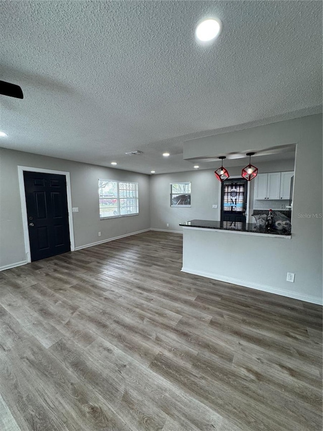 602 Taylor Blvd, Winter Haven, FL 33880 - unfurnished living room with a textured ceiling, wood finished floors, recessed lighting, and baseboards
