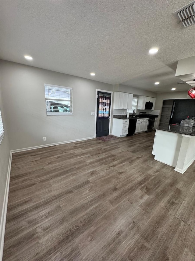 602 Taylor Blvd, Winter Haven, FL 33880 - kitchen featuring dark countertops, white cabinets, dishwasher, dark wood-style floors, and a textured ceiling