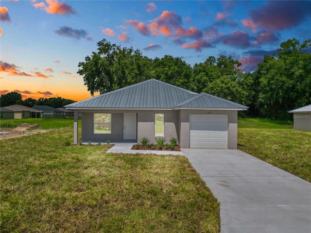 view of front of house featuring a garage and a yard