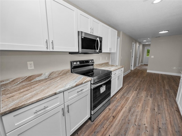 kitchen with light stone counters, dark wood-type flooring, electric stove, and white cabinets