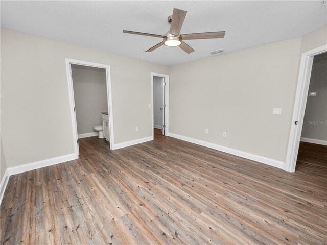 unfurnished bedroom with ceiling fan, hardwood / wood-style floors, and ensuite bath