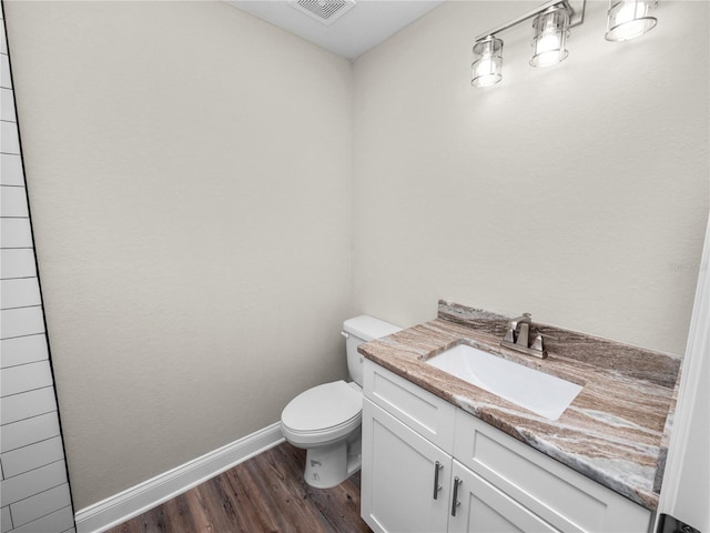 bathroom with toilet, hardwood / wood-style flooring, and vanity