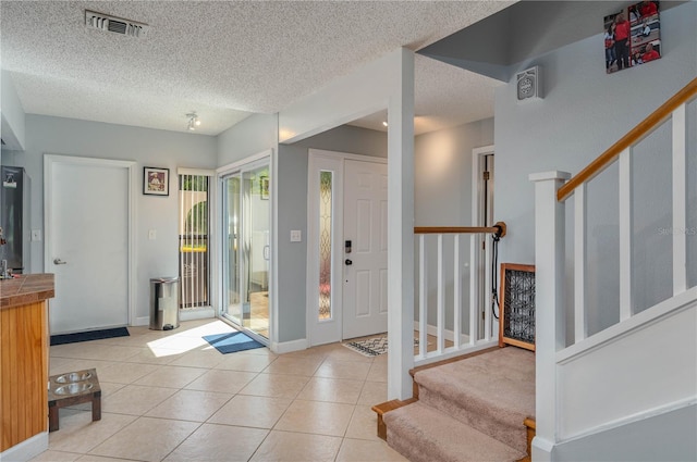 entrance foyer featuring a textured ceiling and light tile patterned floors