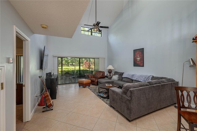 living room with a textured ceiling, high vaulted ceiling, light tile patterned flooring, and ceiling fan