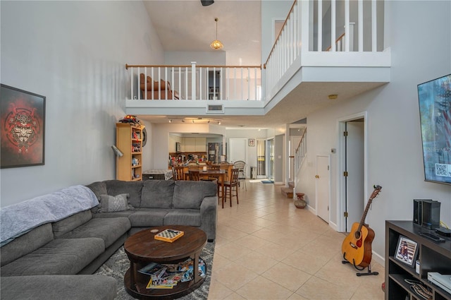 living room featuring a towering ceiling and light tile patterned floors