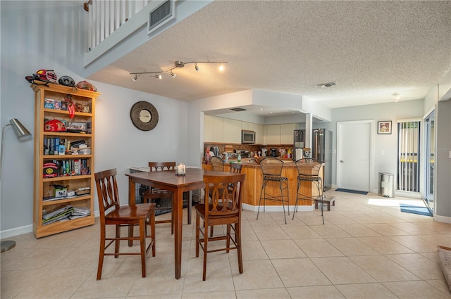 dining area with light tile patterned floors and a textured ceiling