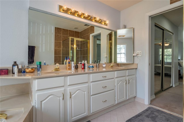 bathroom with tile patterned flooring, vanity, ceiling fan, and an enclosed shower