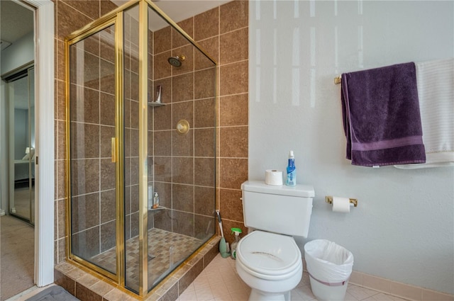 bathroom featuring tile patterned flooring, a shower with shower door, and toilet