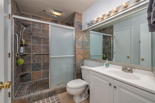 bathroom with vanity, toilet, tile patterned floors, and a shower with door