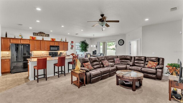 carpeted living room with sink and ceiling fan