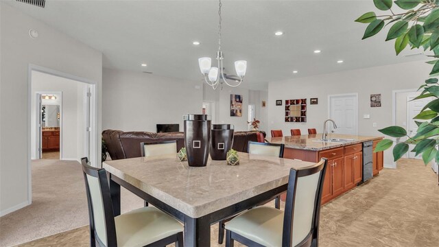 dining area with sink, a chandelier, and light colored carpet