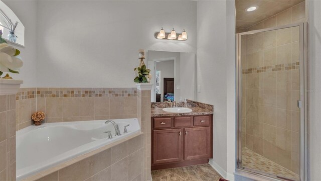 bathroom featuring vanity, plus walk in shower, and tile patterned flooring