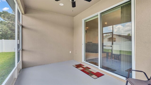 unfurnished sunroom featuring ceiling fan