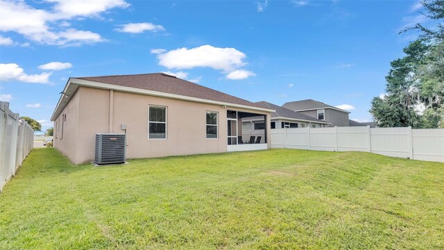 rear view of house featuring a lawn and cooling unit