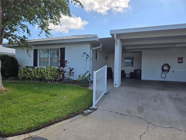 single story home featuring a front lawn and a carport