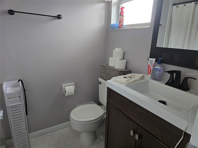 full bathroom featuring baseboards, vanity, and toilet