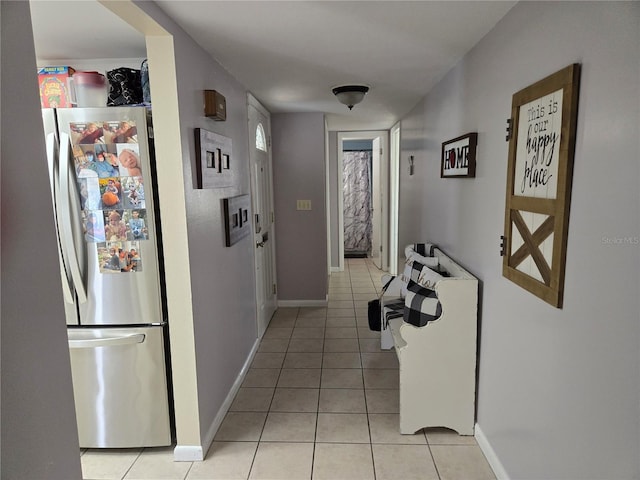 corridor with light tile patterned floors and baseboards