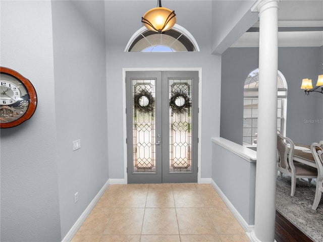 tiled foyer with decorative columns and french doors