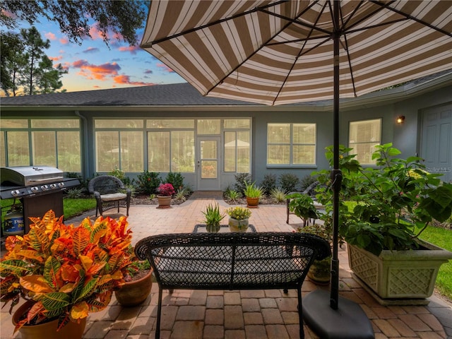 patio terrace at dusk featuring a grill