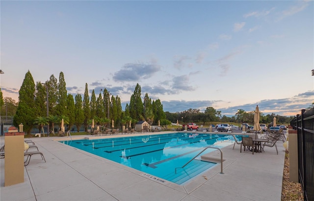 pool at dusk with a patio