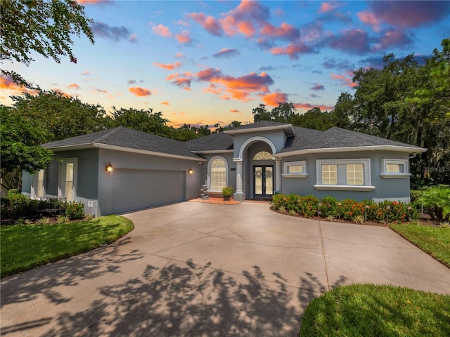 view of front of home with a garage and french doors