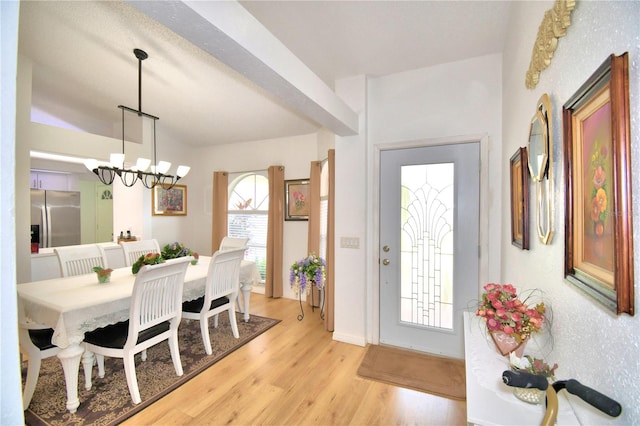 foyer featuring light hardwood / wood-style floors, a wealth of natural light, and an inviting chandelier