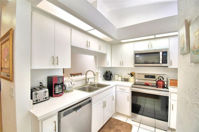 kitchen featuring sink, white cabinets, light tile patterned flooring, and stainless steel appliances