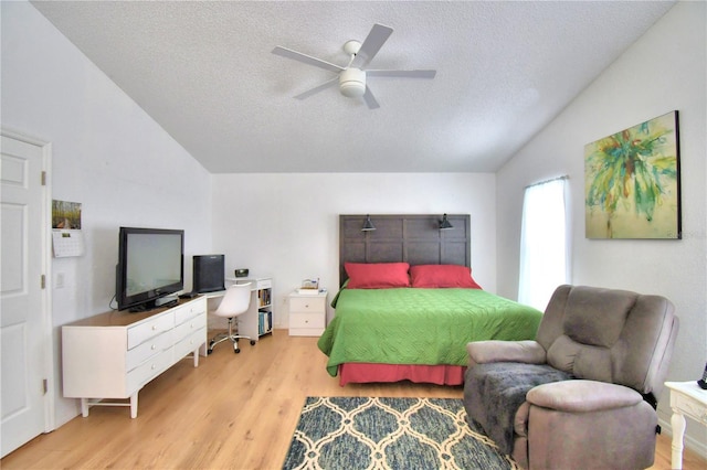 bedroom featuring ceiling fan, vaulted ceiling, a textured ceiling, and light wood-type flooring