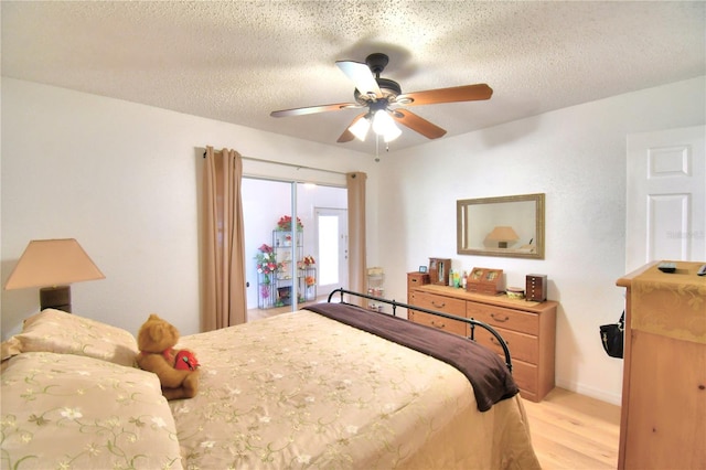 bedroom with ceiling fan, light hardwood / wood-style flooring, and a textured ceiling