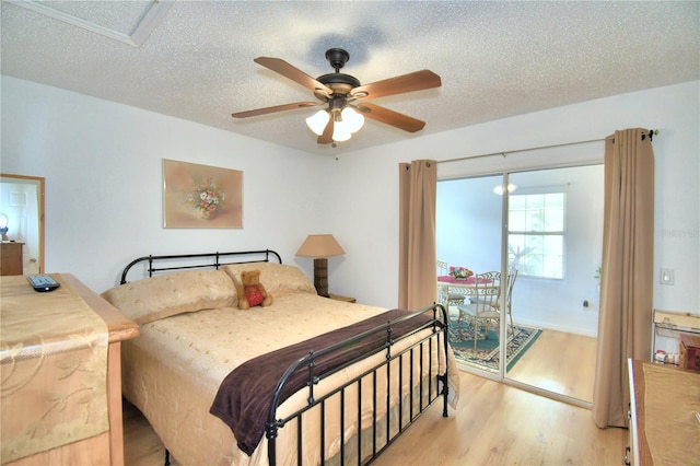 bedroom with a textured ceiling, ceiling fan, and light hardwood / wood-style floors