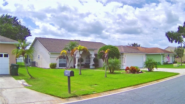 view of front of house with a front yard, central AC, and a garage