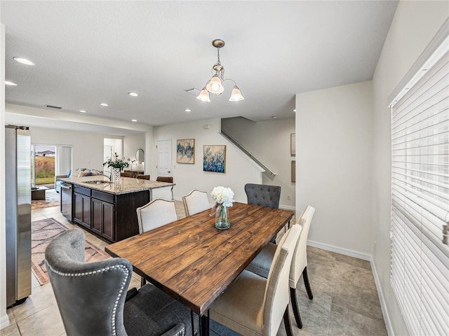 dining space with a chandelier and sink