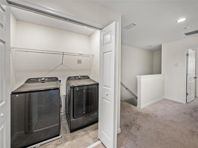 laundry room with washer and dryer and light carpet