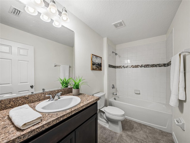 full bathroom featuring toilet, vanity, a textured ceiling, and tiled shower / bath