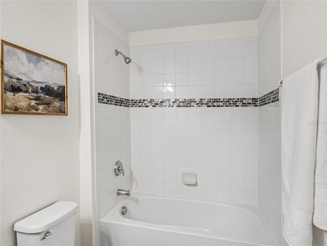 bathroom featuring toilet and tiled shower / bath