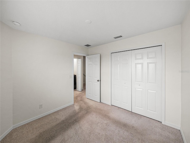 unfurnished bedroom featuring a closet and light carpet