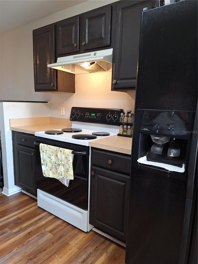 kitchen with light countertops, black refrigerator with ice dispenser, electric range, wood finished floors, and under cabinet range hood