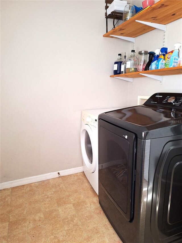 laundry room featuring light tile patterned floors and washing machine and dryer