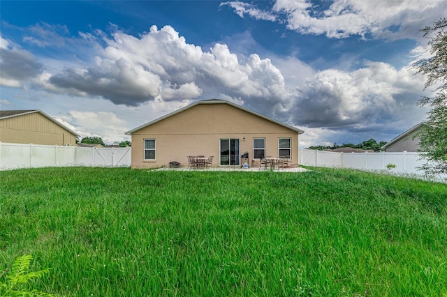 rear view of house featuring a patio and a lawn