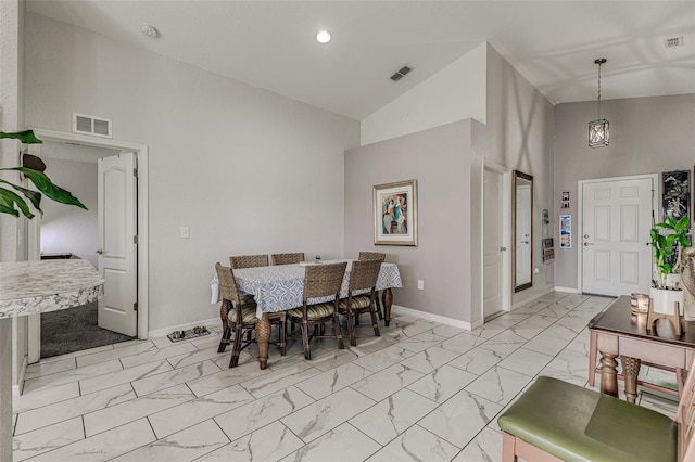 dining space featuring high vaulted ceiling, light tile patterned floors, and an inviting chandelier