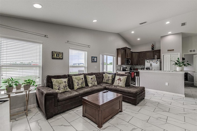 tiled living room featuring high vaulted ceiling