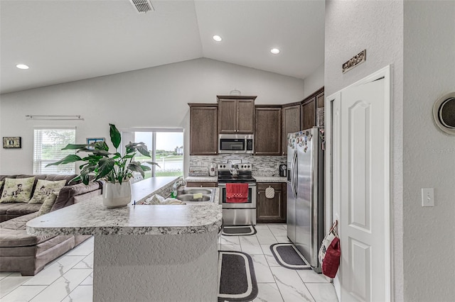 kitchen featuring stainless steel appliances, tasteful backsplash, an island with sink, lofted ceiling, and light tile patterned flooring