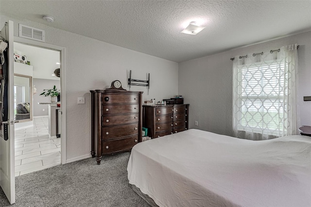 carpeted bedroom featuring a textured ceiling