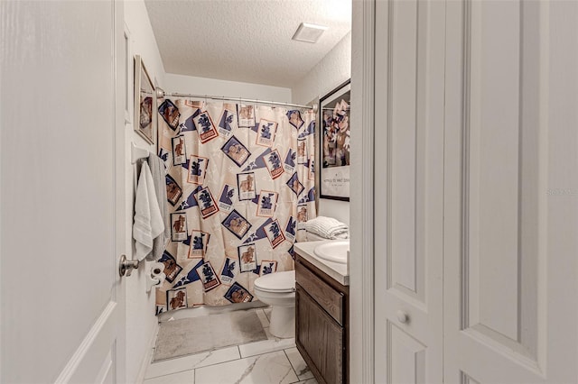 bathroom featuring a textured ceiling, toilet, vanity, and tile patterned floors