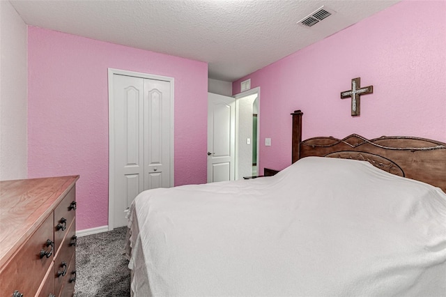 carpeted bedroom with a closet and a textured ceiling