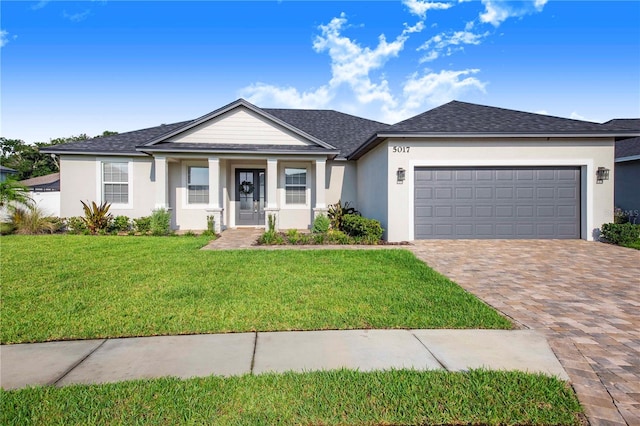 view of front of property with a front yard and a garage