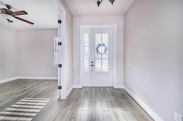 foyer entrance with ceiling fan and wood-type flooring