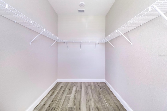 spacious closet featuring light hardwood / wood-style floors